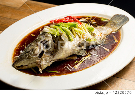 Steamed snapper with soy sauce in white dish 42229576