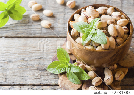 Delicious salted pistachios and fresh mint leaves Delicious salted pistachios and fresh mint leaves 42231308