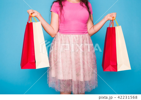 people, sale and consumerism concept - close up of woman with shopping bags over blue background 42231568