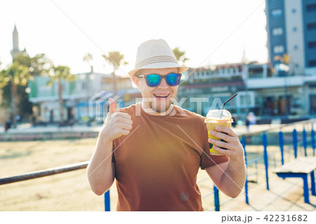 lifestyle, drinks and people concept - man in sunglasses drinking coffee frappe from disposable lifestyle, drinks and people concept - man in sunglasses drinking coffee frappe from disposable 42231682