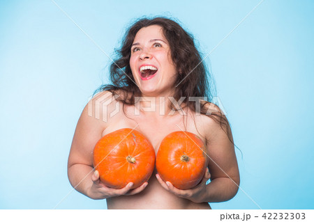 Pumpkins on a female breast - concept silicone breast and plastic surgery. 42232303