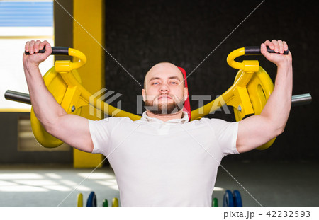 Sport, fitness, training and people concept - Muscular man doing heavy exercise pumping up muscles 42232593