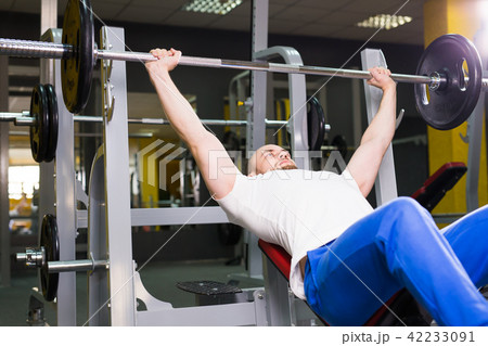 Fitness, athlete, bodybuilding and people concept - Muscular bodybuilder bench press workout 42233091