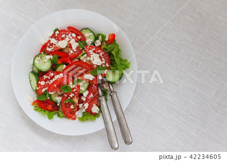 Shopska salad in a white plate on a white tableclo Shopska salad in a white plate on a white tableclo 42234605
