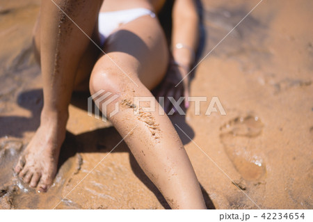 close up legs of a lady with wet sand on them close up legs of a lady with wet sand on them 42234654