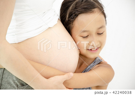 胎動の音を聞いている女の子の写真素材