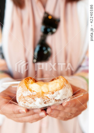 Bitten Japanese Choux cream puff in female hands 42240386
