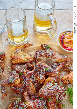 chicken wings, glass cups of beer 42242012