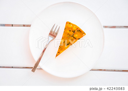 Slice of mango passion fruit coconut cake on white 42243083