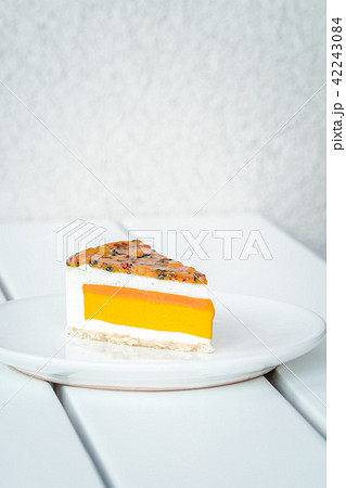 Slice of mango passion fruit coconut cake on white 42243084