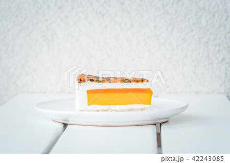 Slice of mango passion fruit coconut cake on white 42243085