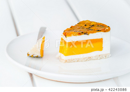 Slice of mango passion fruit coconut cake on white 42243086