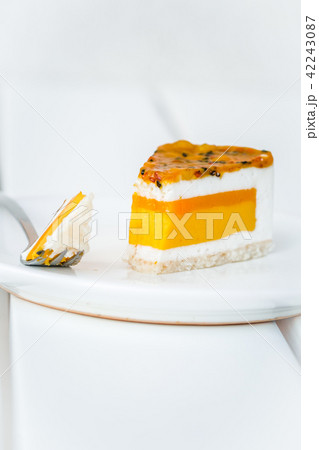 Slice of mango passion fruit coconut cake on white 42243087