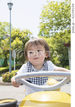 遊園地で乗り物に乗る幼児 男の子の写真素材