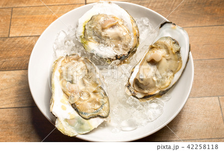 Fresh opened oyster offered as top view. 42258118