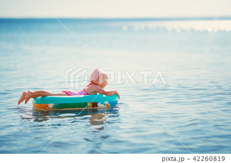 little boy walking at the beach in straw hat 42260819