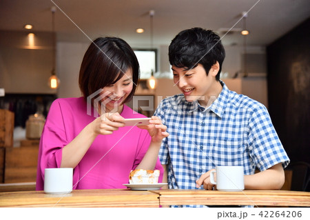 カフェでスマホを楽しむ若い男女 42264206
