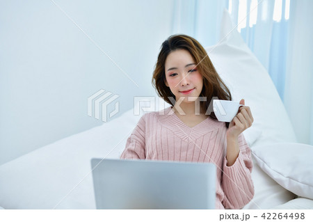 Winter Concept. Women are playing a notebook in the bedroom. Wom 42264498