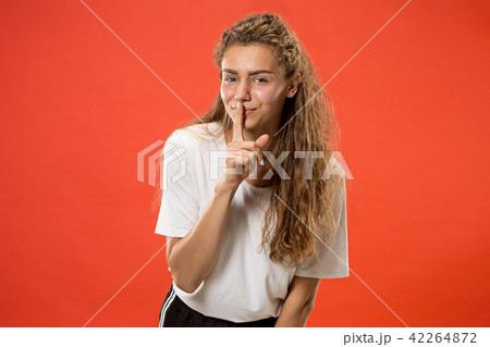 The young woman whispering a secret behind her hand 42264872