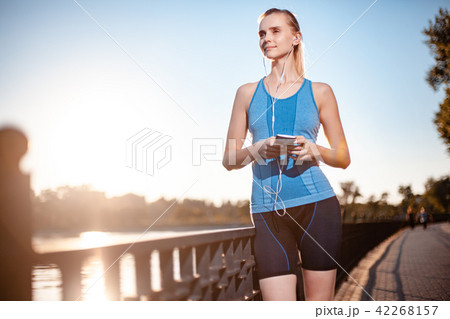The girl in a t-shirt  is standing by the lake 42268157