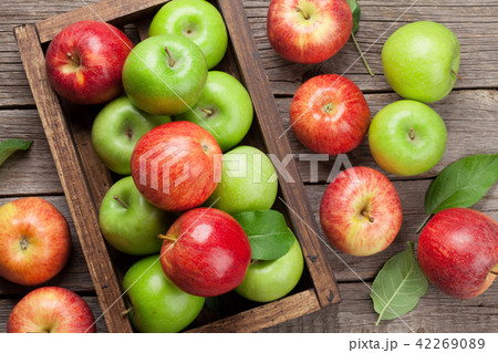 Green and red apples in wooden box 42269089