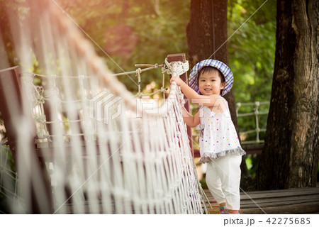 Little girl playing climbing on the rope bridge 42275685