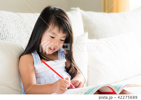 Little girl smiling and holding red pencil Little girl smiling and holding red pencil 42275689