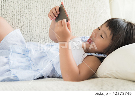 Little girl having fun to play game on smart phone 42275749