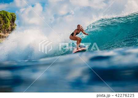 Surfer girl on wave in ocean Surfer girl on wave in ocean 42276225