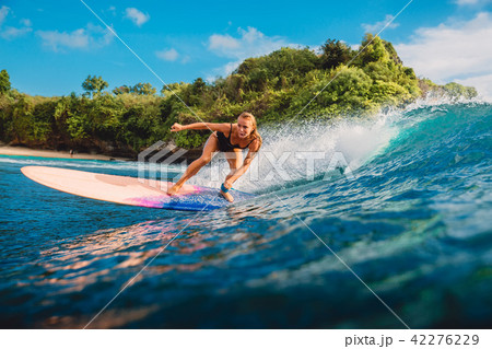Surfer woman at surfboard on ocean wave 42276229