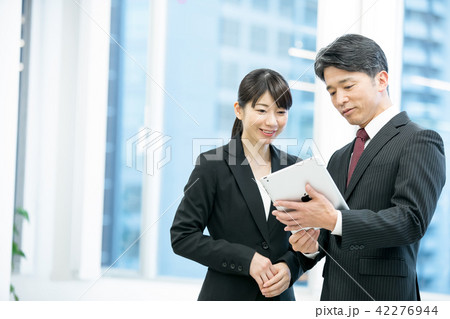 ビジネスイメージ タブレット端末を使うビジネスマンと女性会社員 幹部社員 ビジネスイメージ タブレット端末を使うビジネスマンと女性会社員 幹部社員 42276944
