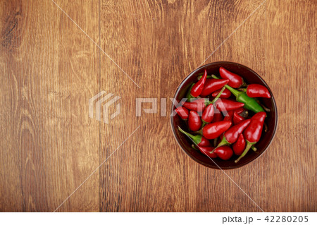 red chili pepper in bowl on wooden table 42280205
