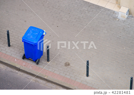 Blue trash can on street pavement 42281481