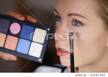 Woman getting make up done by artist Woman getting make up done by artist 42281482