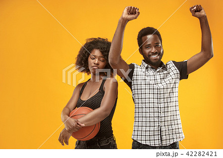 The happy and angry fans on colored gold background. 42282421