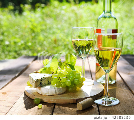 Cheese, grapes and two glasses of the white wine 42285239