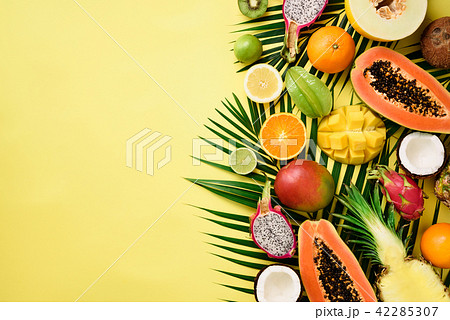 Exotic fruits and tropical palm leaves on pastel 42285307