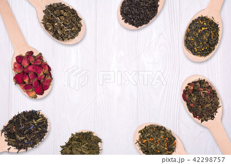 Frame of dry herbal teas in wooden spoons on a white background Frame of dry herbal teas in wooden spoons on a white background 42298757
