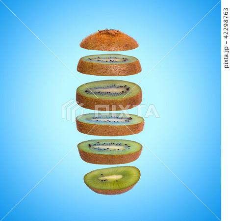 Creative concept with flying kiwi. Sliced kiwi on blue background 42298763