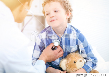Doctor and child patient. Physician examines little boy by stethoscope. Medicine and children's 42299471