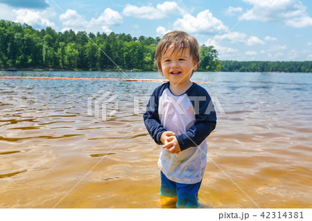 Toddler boy playing in a lake on a summer day 42314381