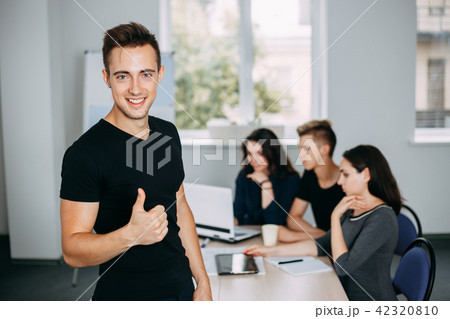 confident young man gesturing thumb up confident young man gesturing thumb up 42320810
