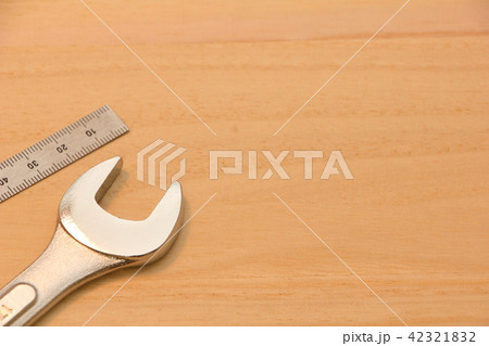 木の板の上に置かれた金属製の定規(直尺)とスパナ 木の板の上に置かれた金属製の定規(直尺)とスパナ 42321832