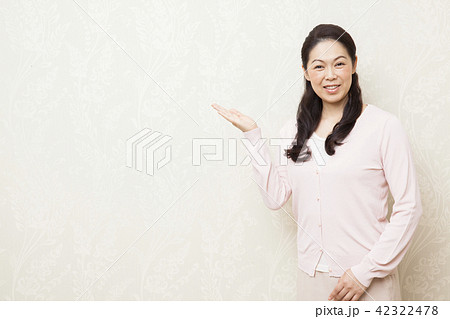 片手を上げるポーズの女性の写真素材