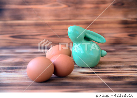 Easter ceramic rabbit with eggs on wooden background. 42323616