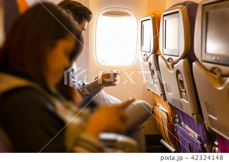 Couple using smartphone in the airplane seat 42324148