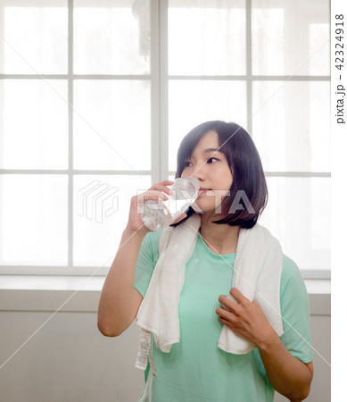 Woman drinking water after exercise Woman drinking water after exercise 42324918