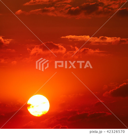 Cloudy sky and bright sun rise over the horizon. 42326570