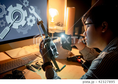 Technician using screwdriver for repairing drone 42327895