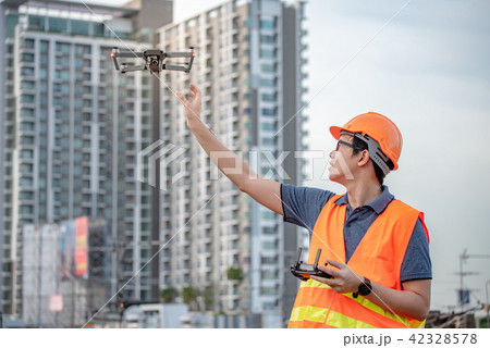 Engineer man flying drone over construction site Engineer man flying drone over construction site 42328578